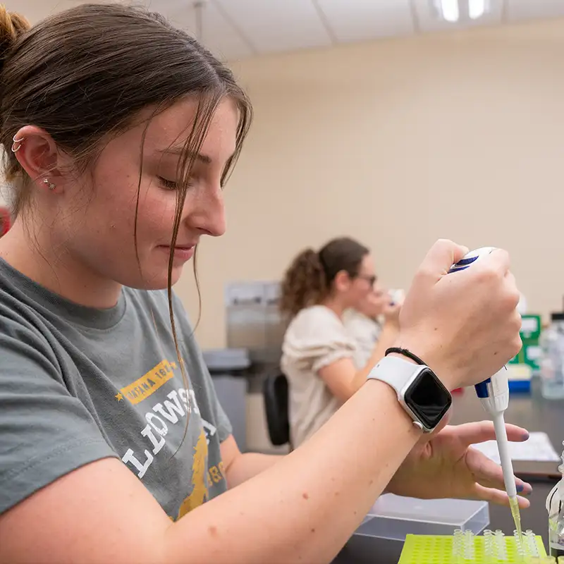 A female student working with a pipette in a lab