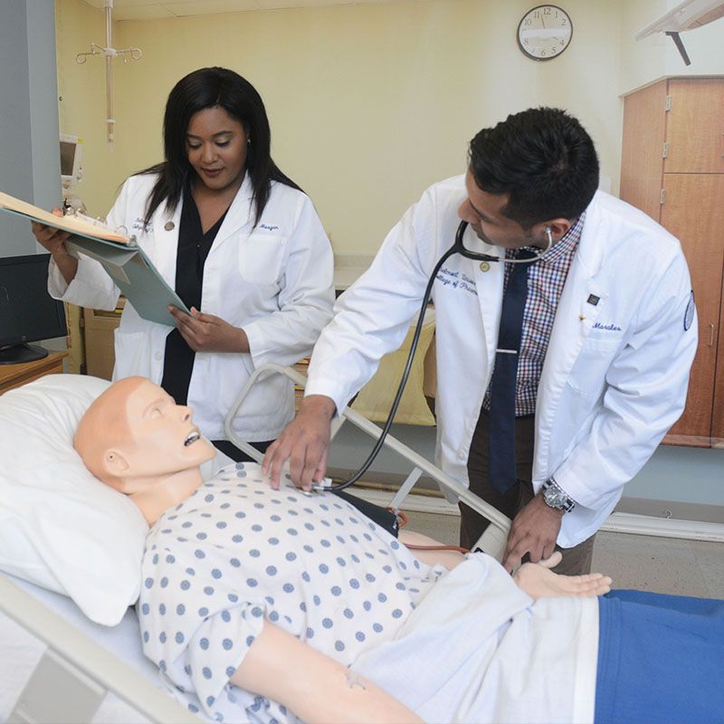 Pharmacy Students working with a simulator