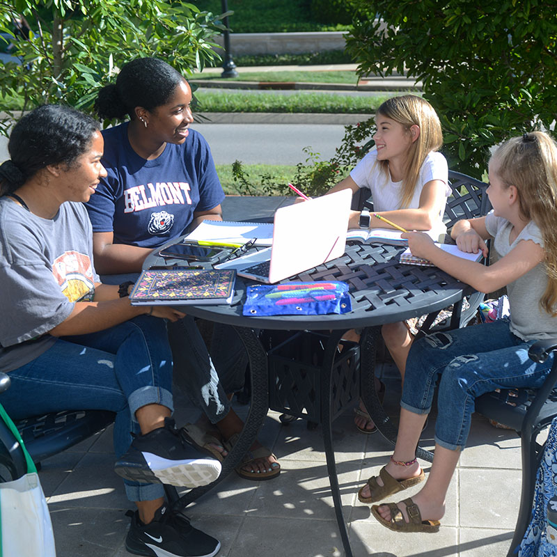 Two Education students working with two children outside