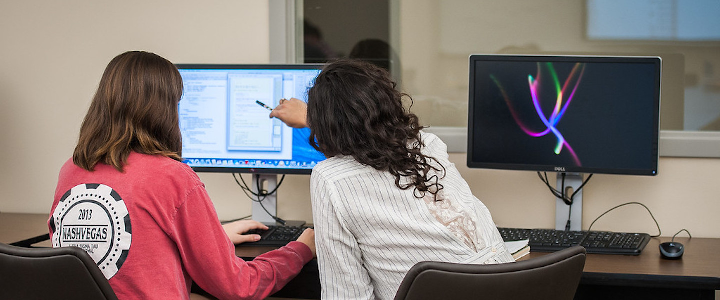 two women work on computer together