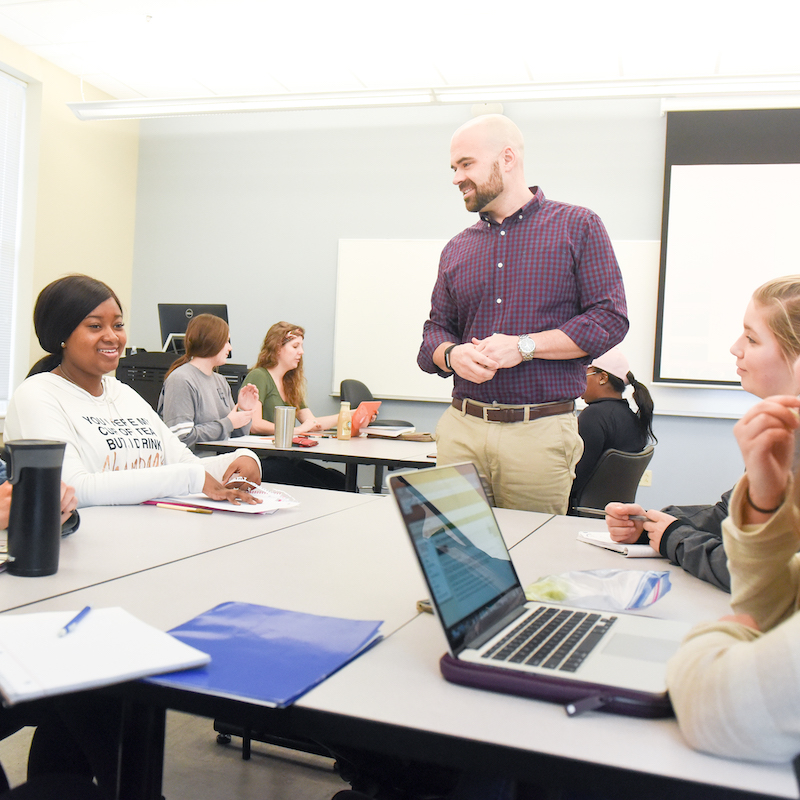 Teacher talks to student in class room during class small groups