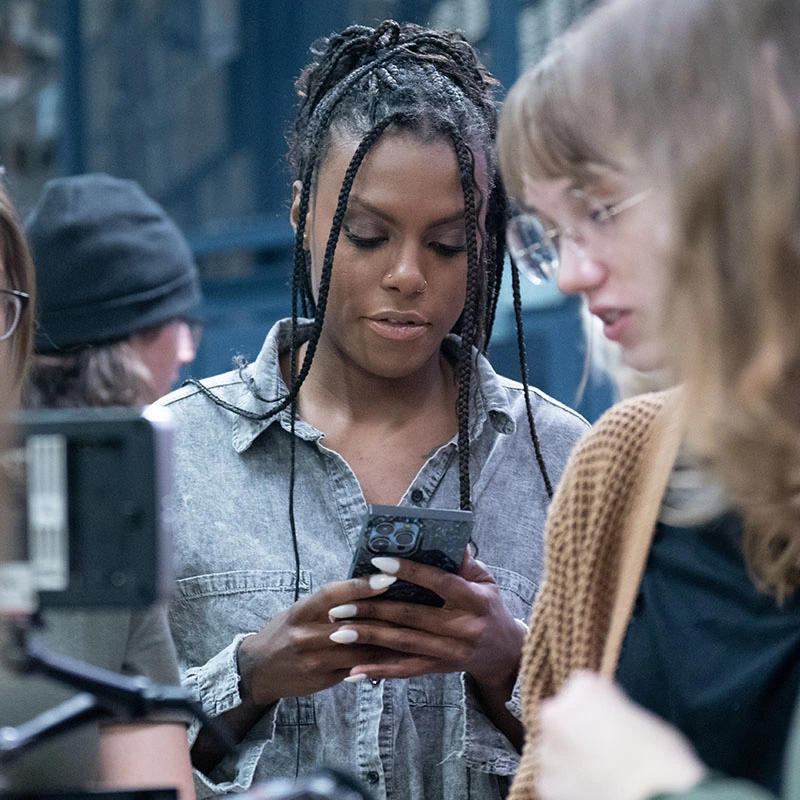 A student checking her phone on a video shoot