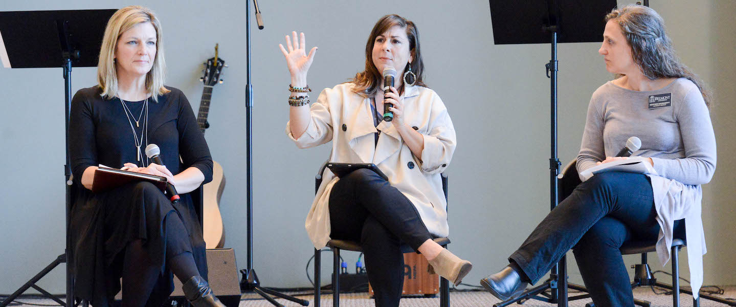 Women sit in the Chapel speaking to students