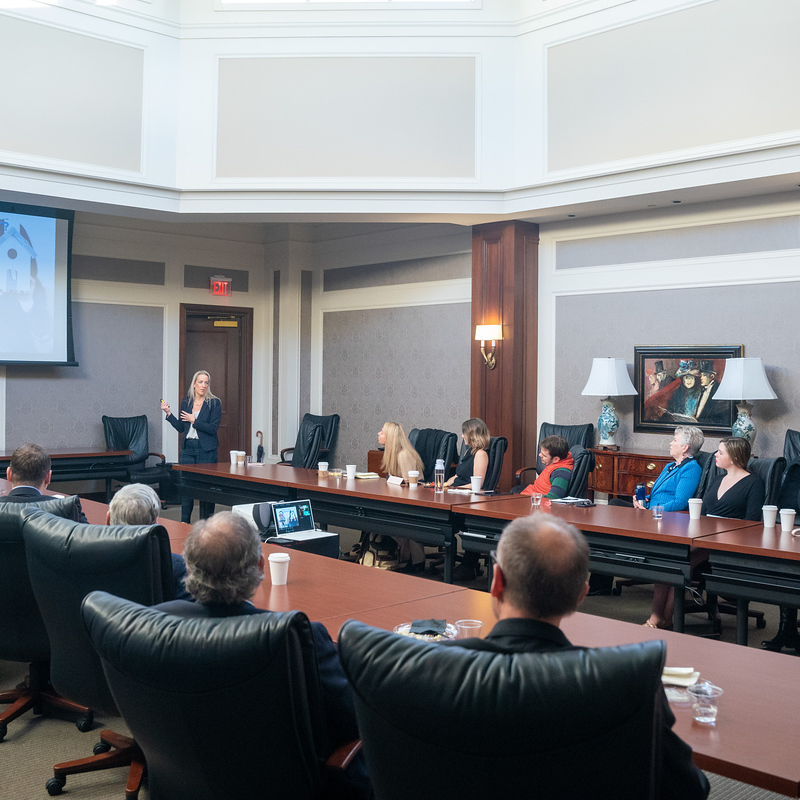 Student giving a presentation in a board room