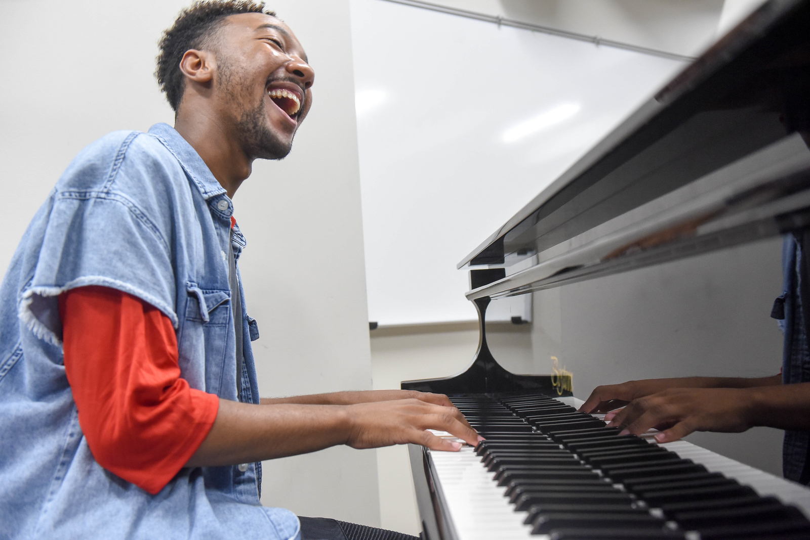 man singing while playing the piano