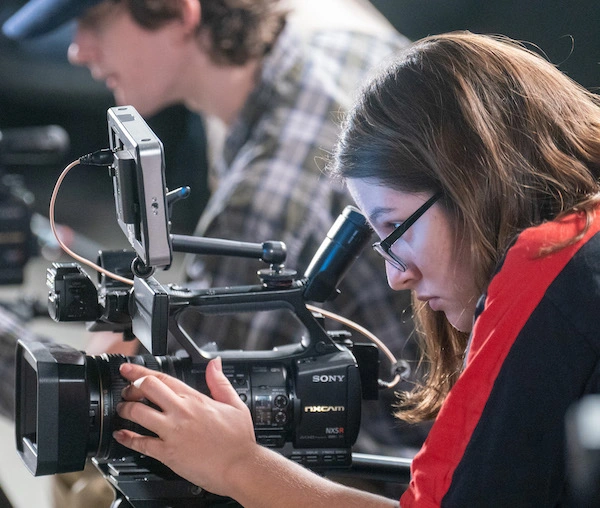 Student looking through camera lens