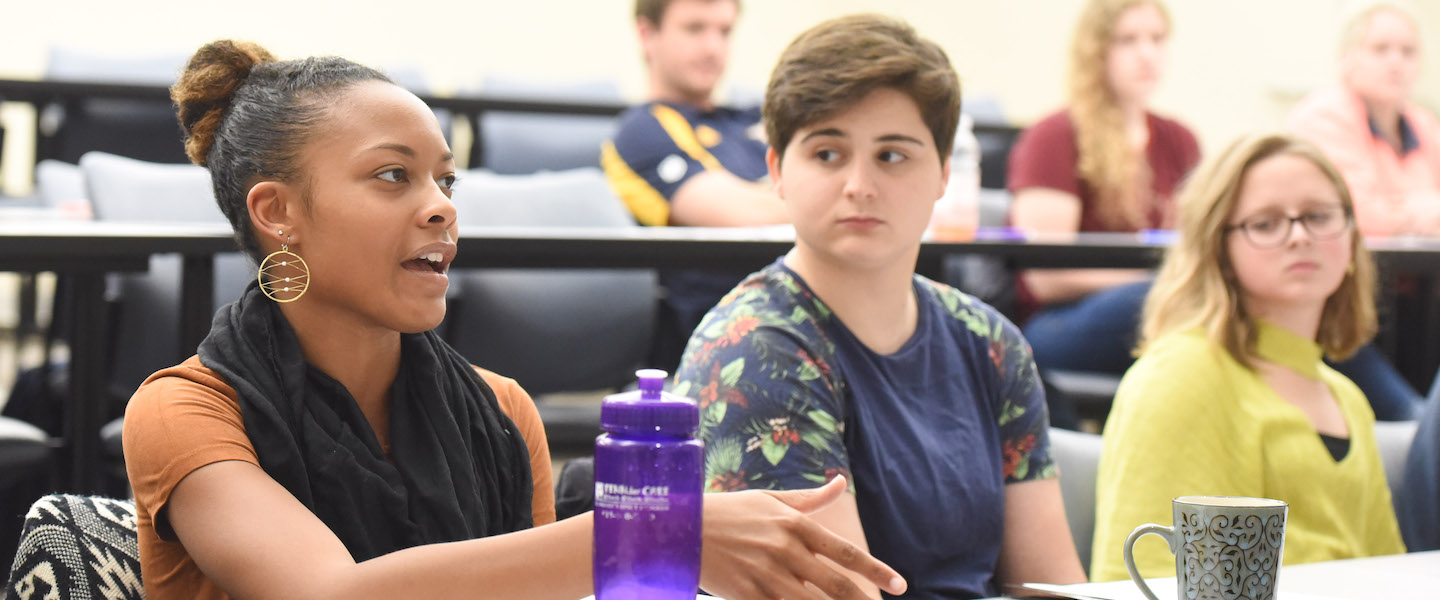 Three students discuss in a classroom at Belmont University