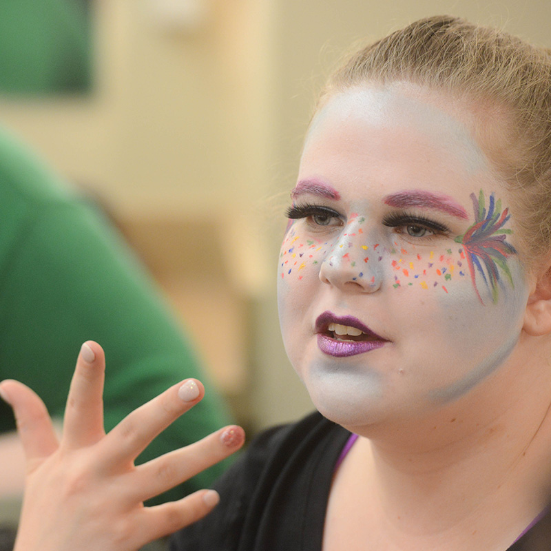 Close-up image of a female student's face with dramatic stage makeup.