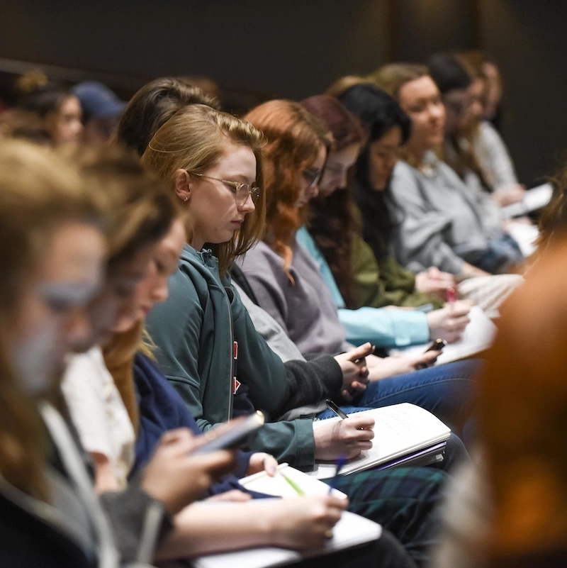 Students in class taking notes