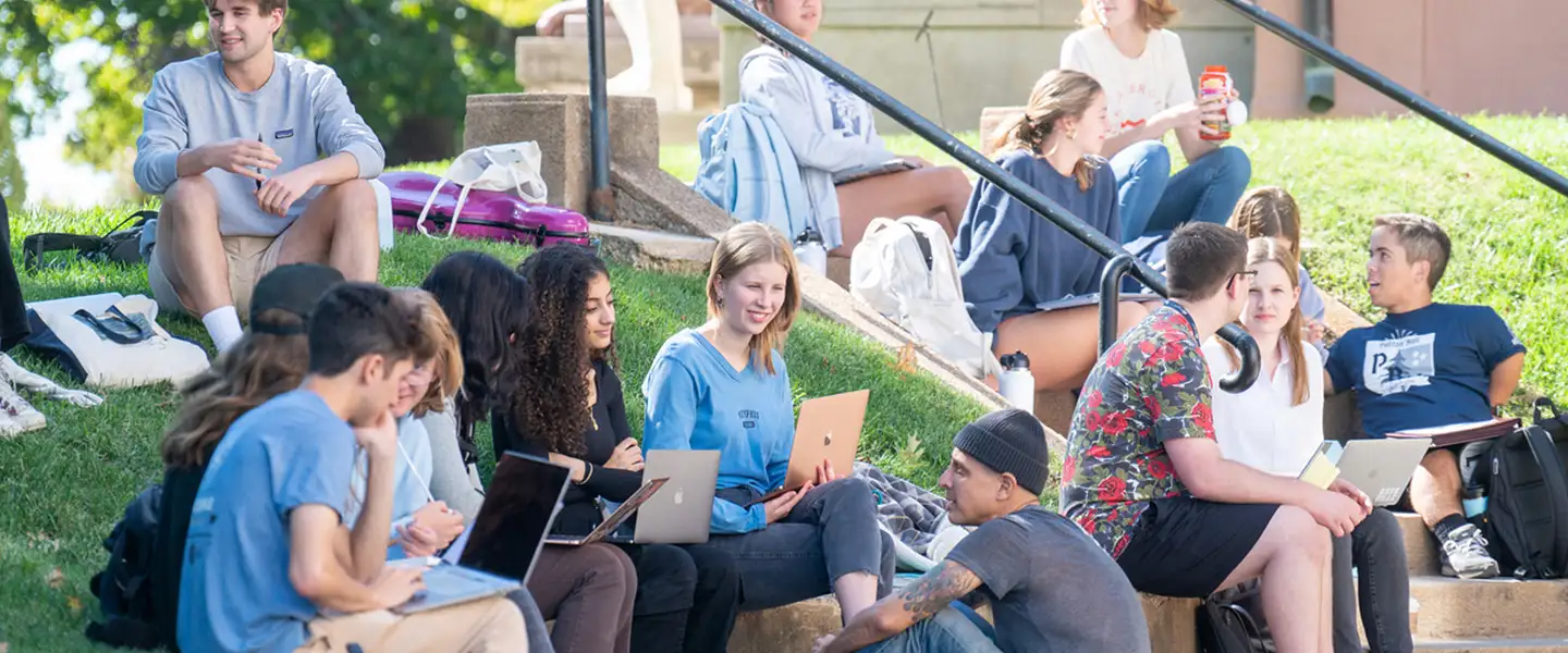 Students sitting outside having class with their professor