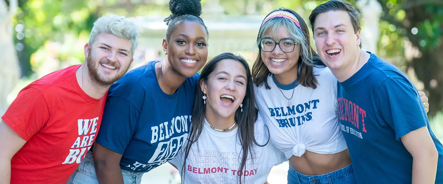 Five students smiling at the camera in a cheerful embrace