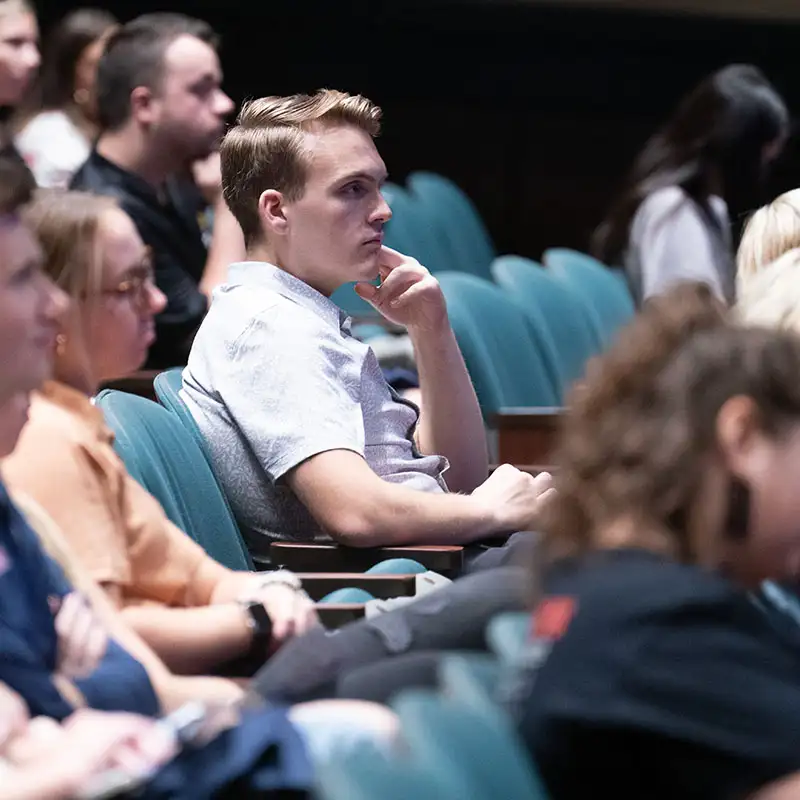 Graduate student watching a lecture in Massey Concert Hall