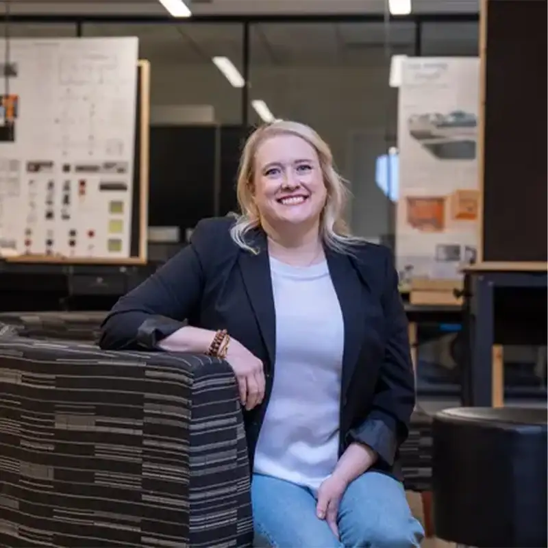 An indoor photo of an Adult Student seated and smiling