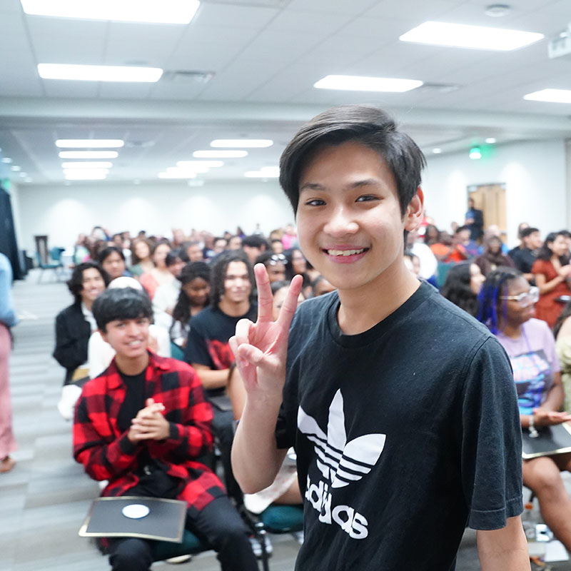 Student showing a peace sign at a Bell Tower Scholars event