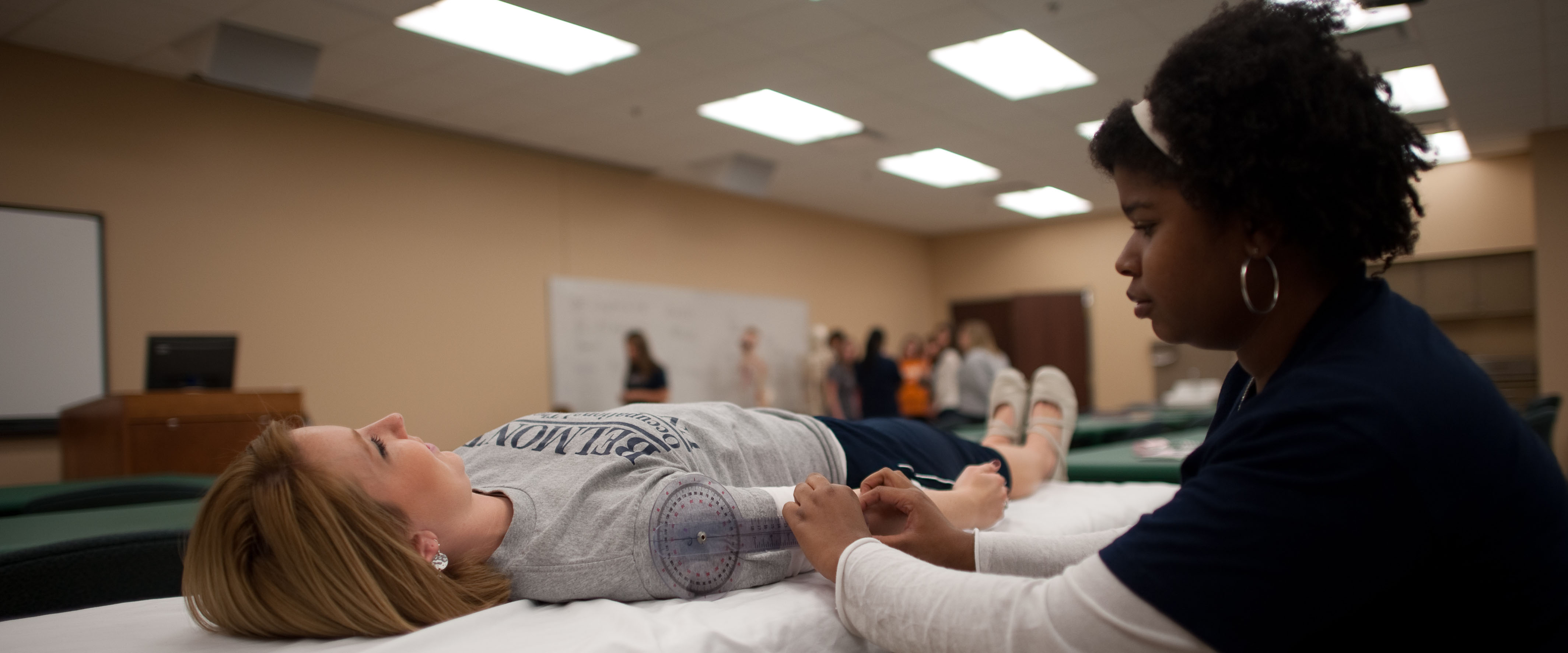 Students working on each other as patients in a PT lab