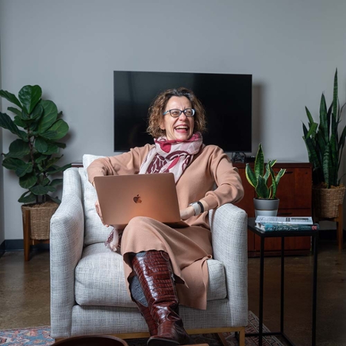 Woman sitting in a chair working on a laptop