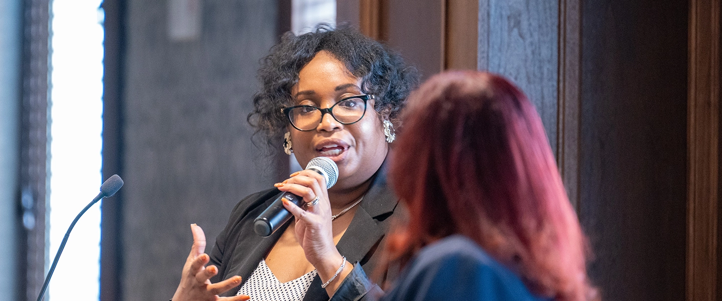 A woman speaking at a podium into a microphone