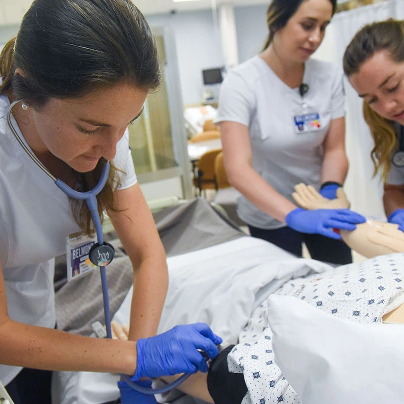 Nursing student checking the heart rate of a patient simulator