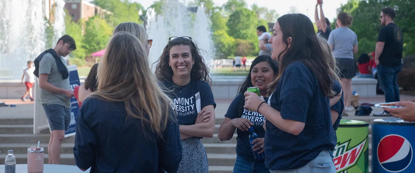 Grad students talk and laugh on lawn during grad student lawn takeover