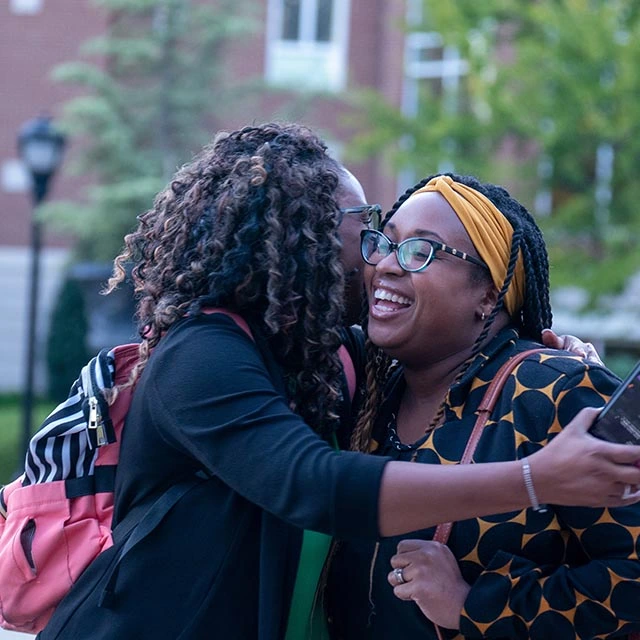 Two women hugging outside in freedom plaza"