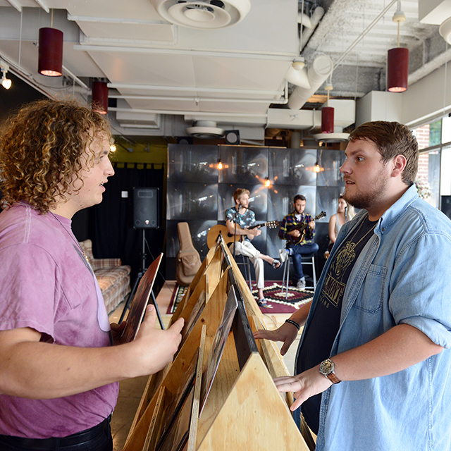 Two students having discussion while looking at records in student run record shop on campus