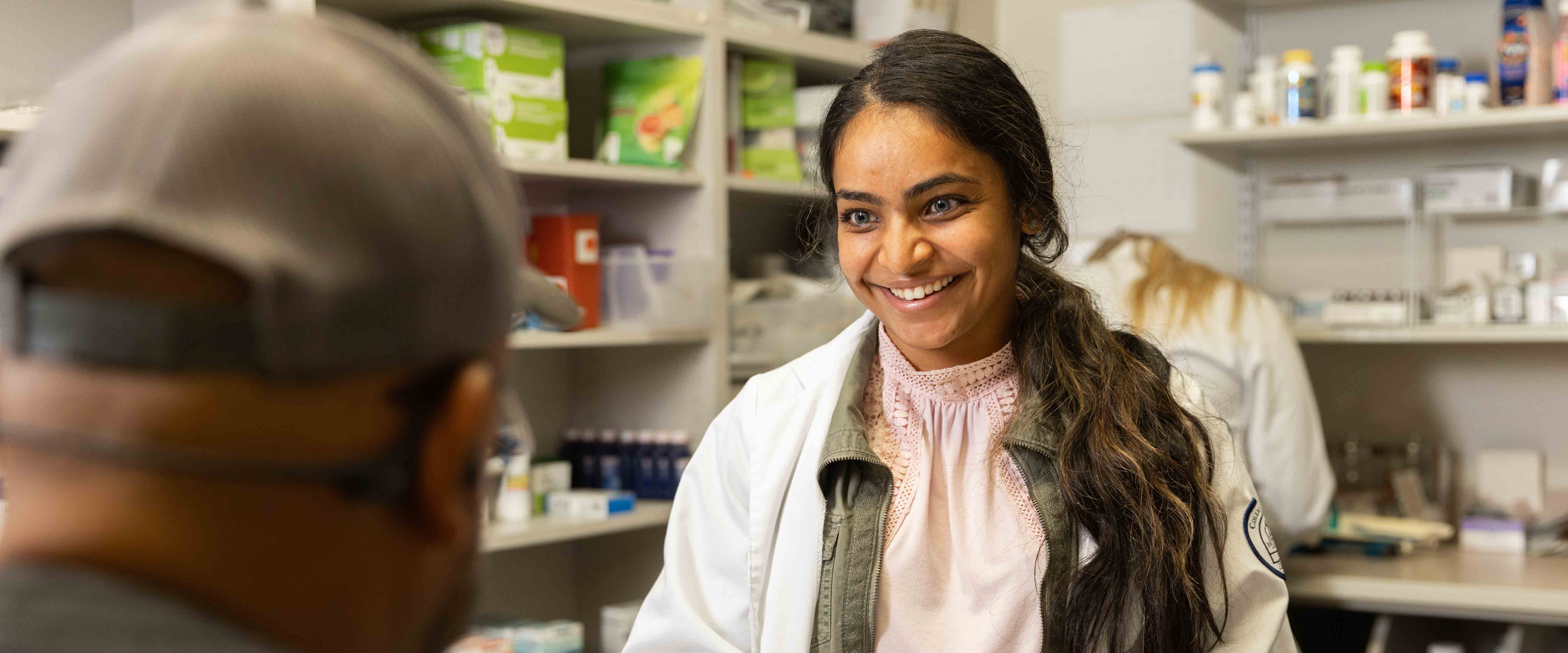 Medical school student talking to patient in pharmacy