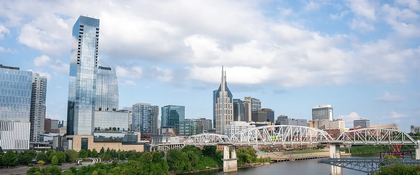 An outdoor photo of the skyline of downtown Nashville facing west on a partly cloudy day