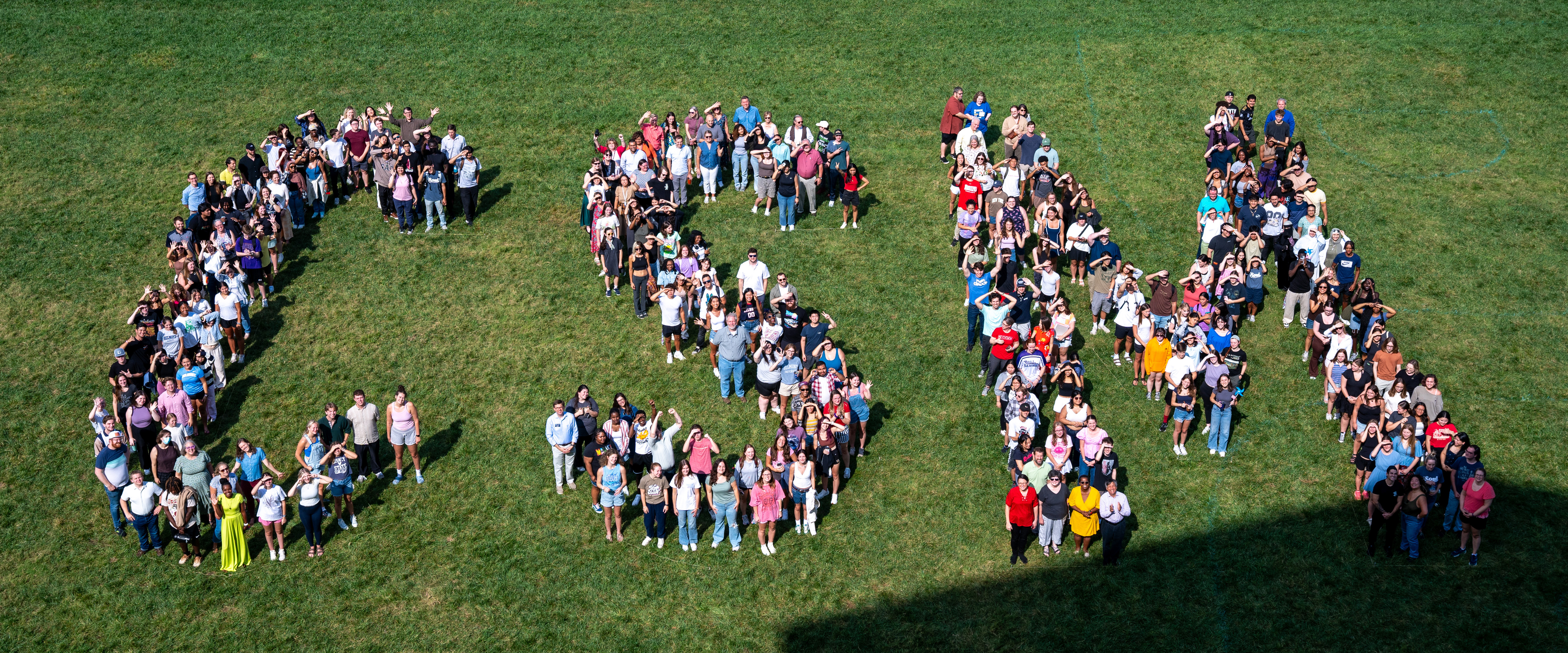 CSM students, faculty and staff gather for a group photo spelling out "CSM" on the lawn.