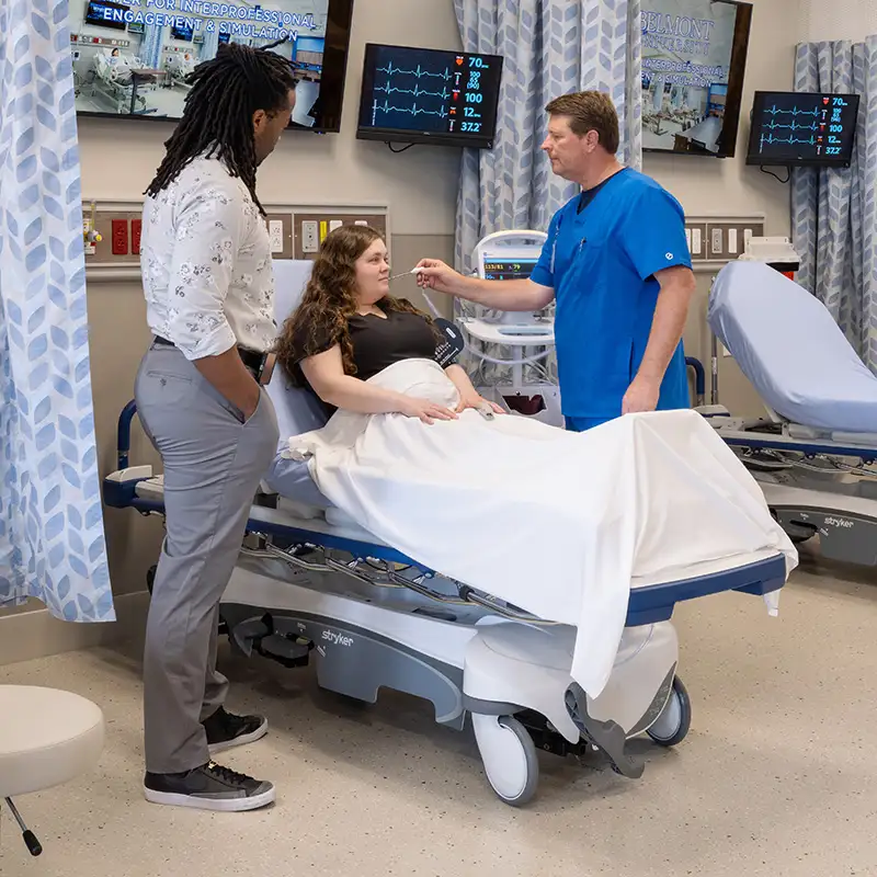 Doctor taking patient temperature in hospital room