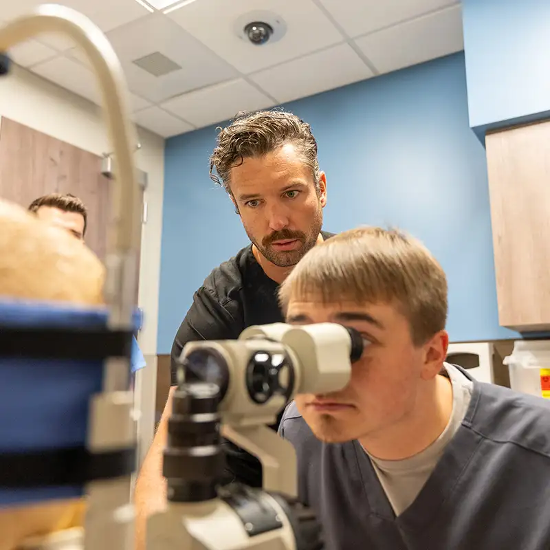 Student looking at mannequin eyes during optometry lab