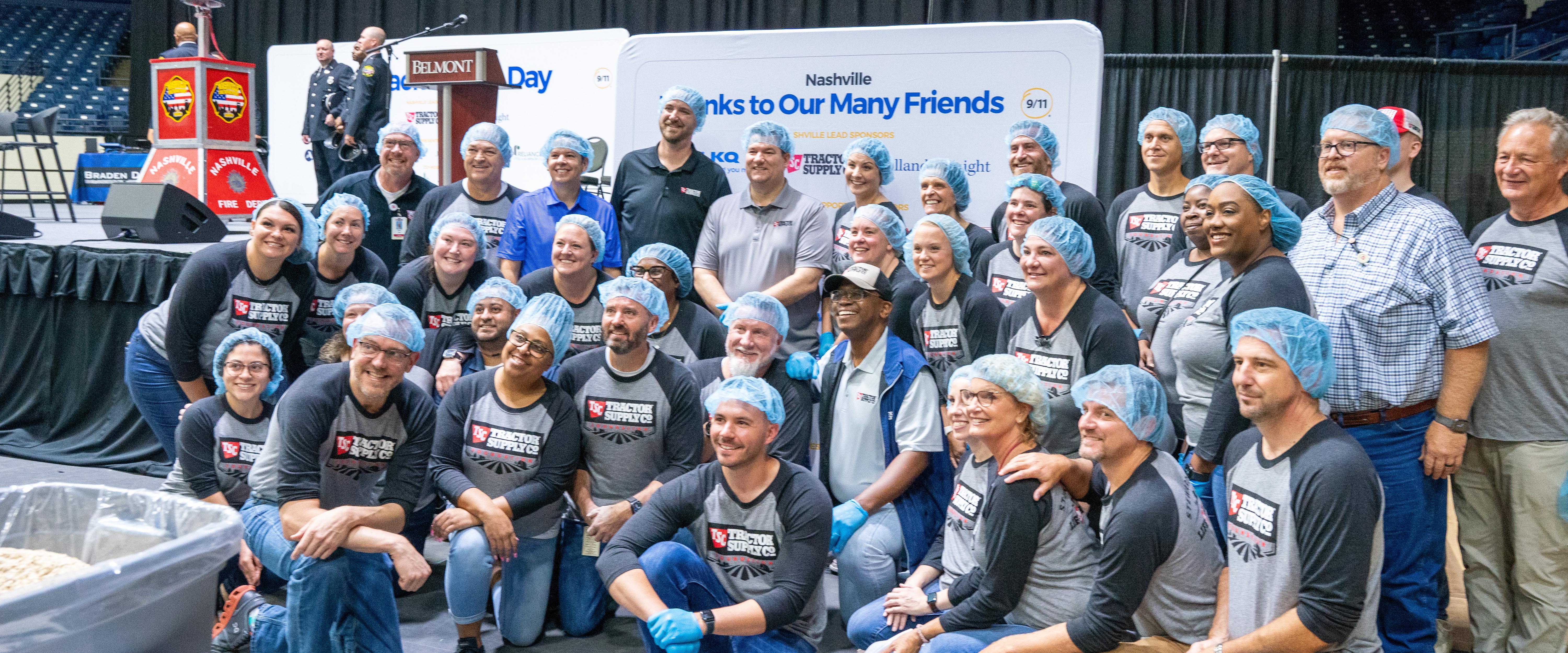 Belmont faculty and staff pose for a picture in hair nets and matching T-shirts during Meal Pack for 9/11 Day.