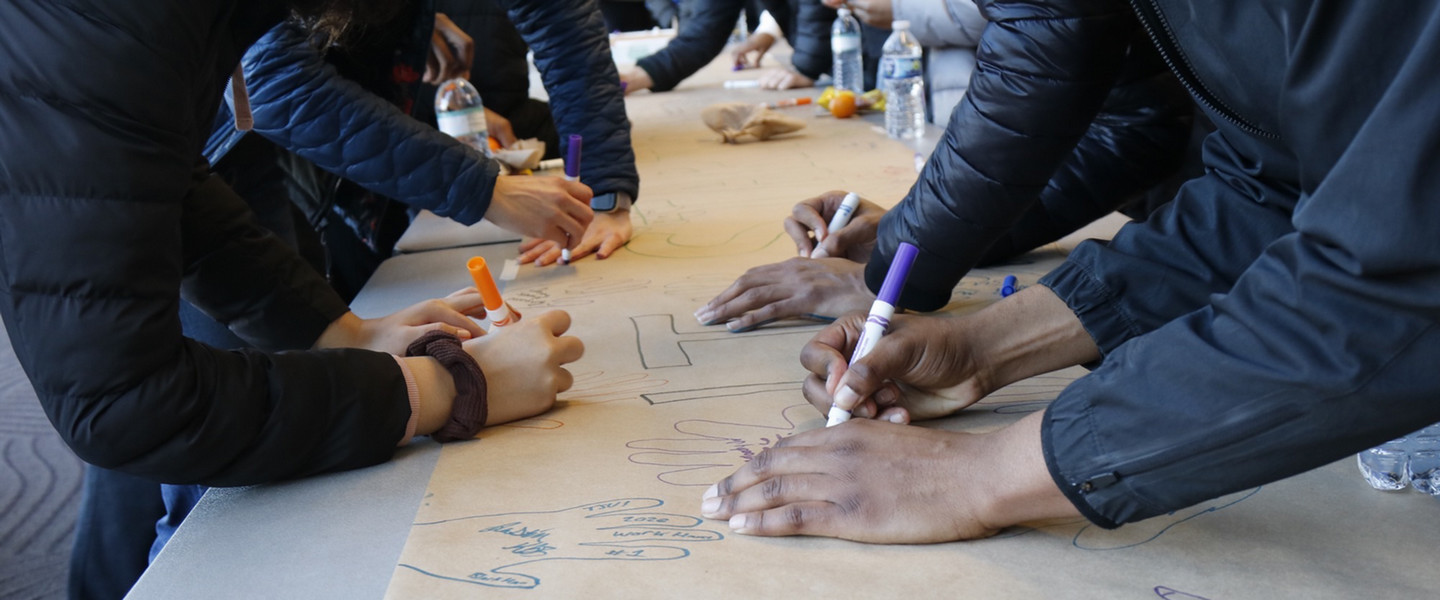 students creating art piece with hands and markers