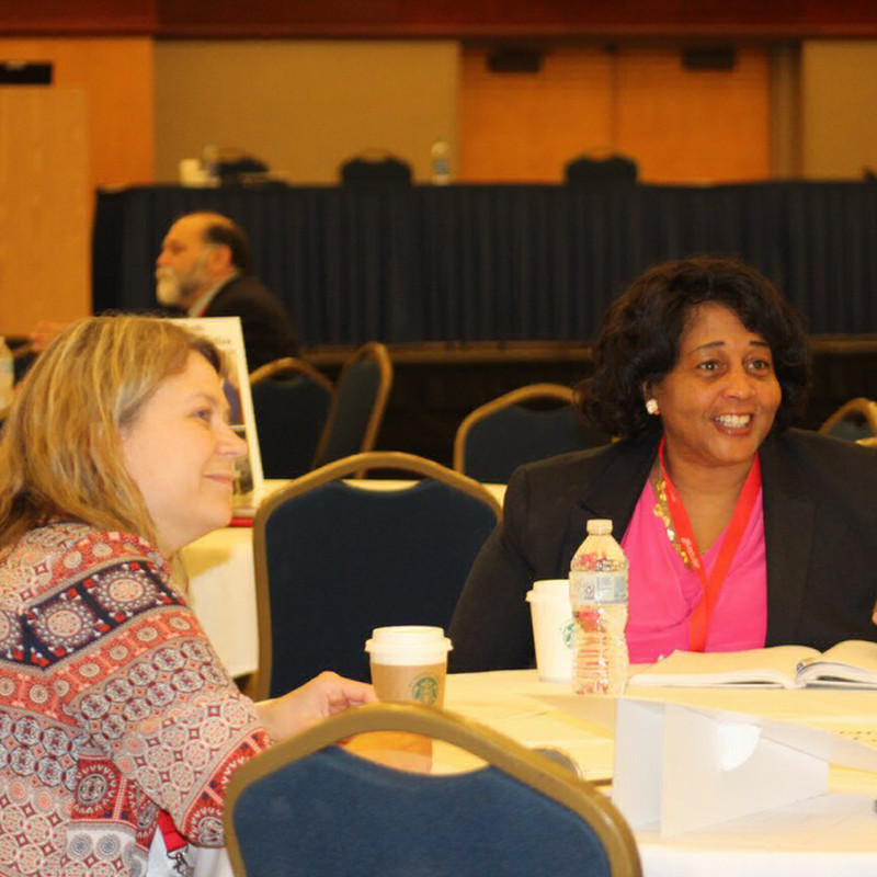 faculty members sit at a roundtable in discussion