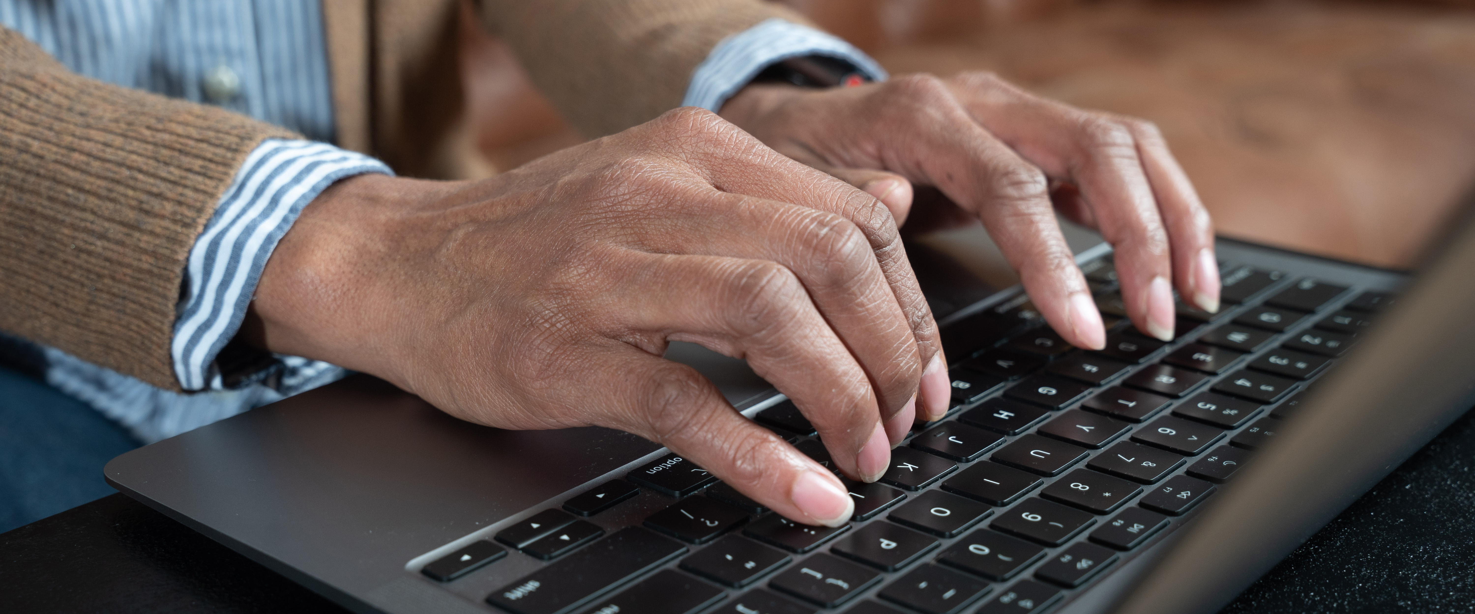 Close up of hands typing on a laptop