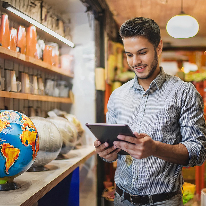 a person on an iPad at a small local business smiling