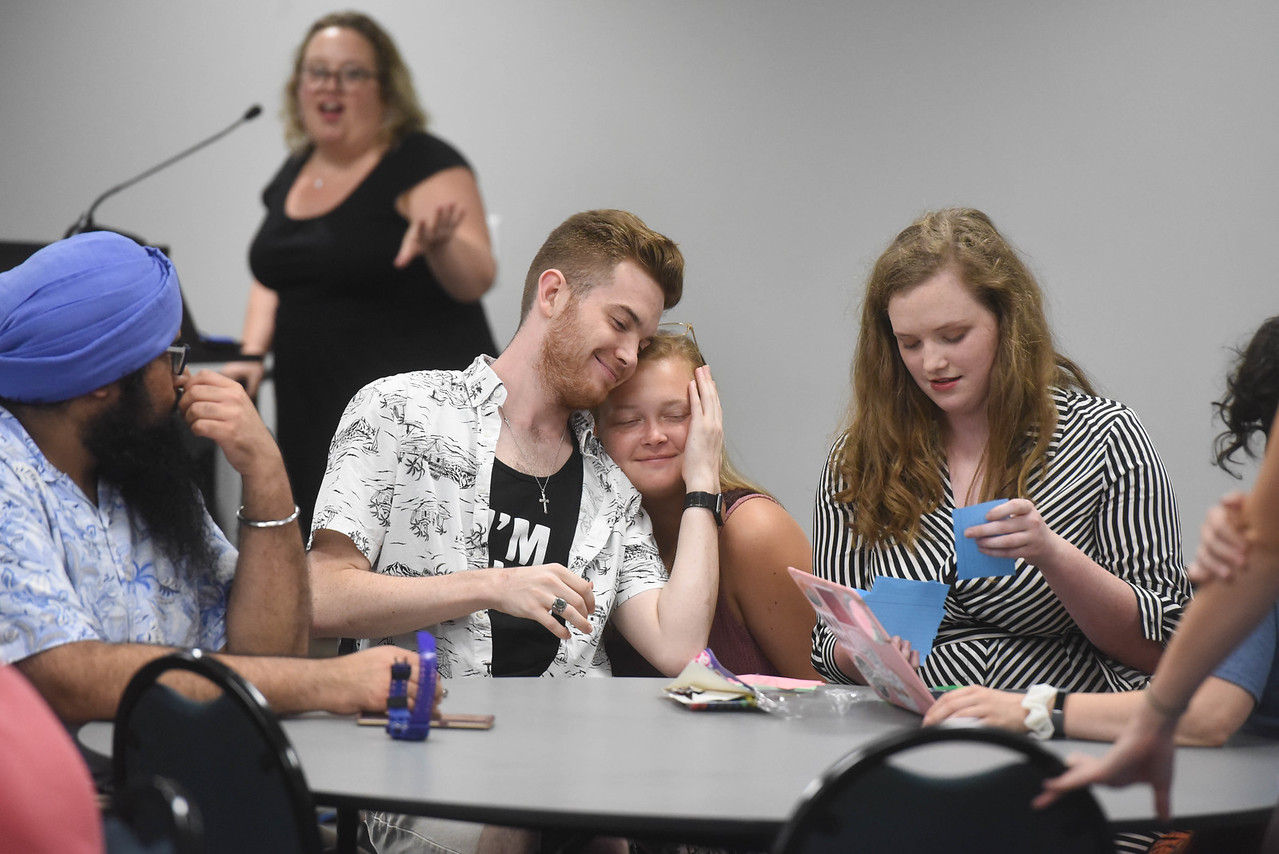 Students smile and embrace at a roundtable