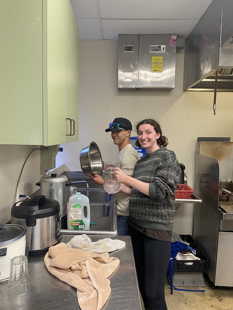 Two students wash dishing in the kitchen at Jacob's Well in Memphis