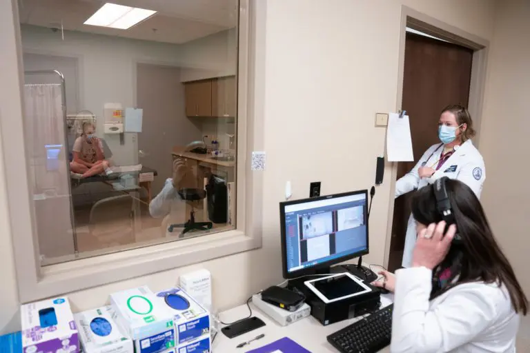 faculty observe nursing students in a simulation lab