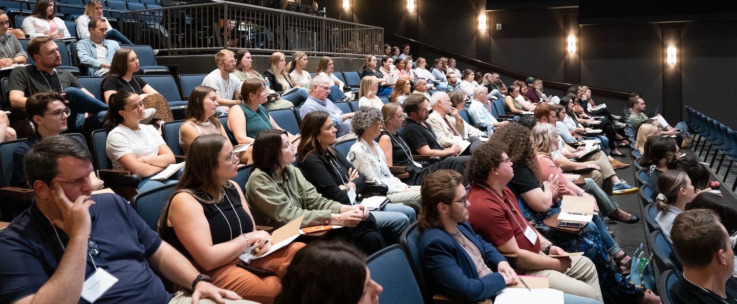 attendees listening to session at 24/7 conference in Johnson Large Theater