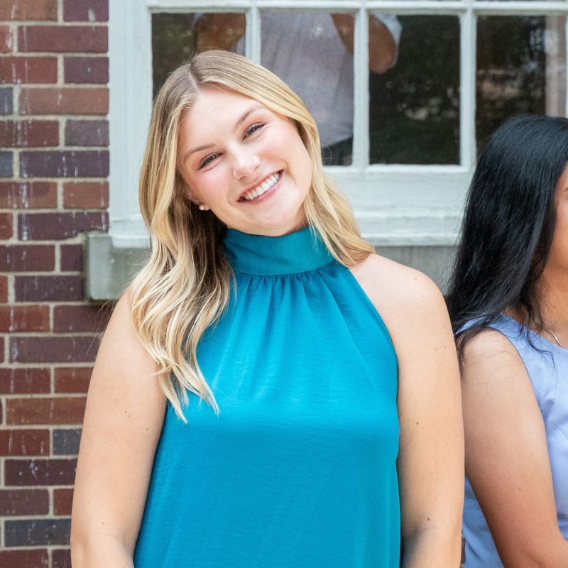 Luce smiling in a blue dress