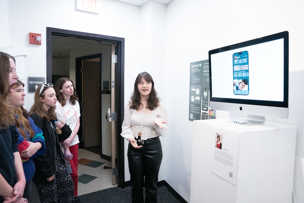 Student presenting her experiential design project at gallery opening