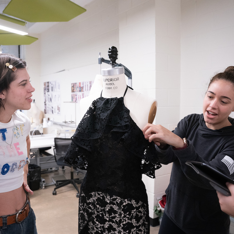 O'More fashion students examining a garment in class