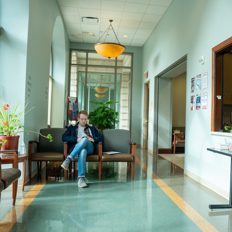 student sitting in a health clinic waiting room