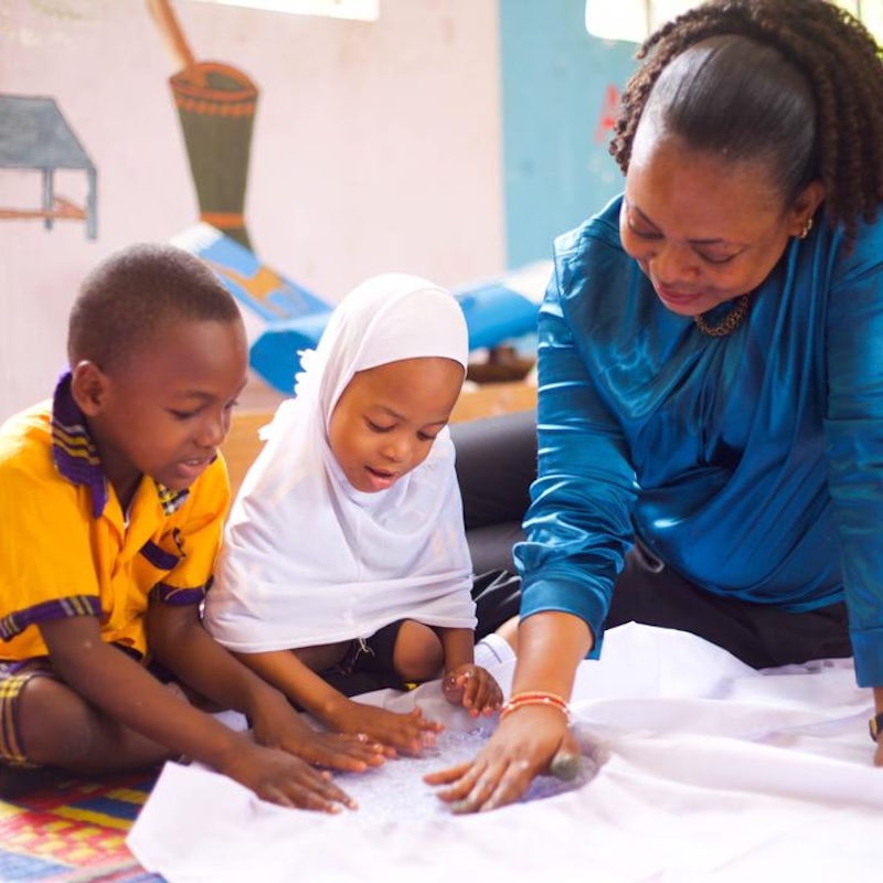 A teacher at Mbande Primary School collaborates with her students