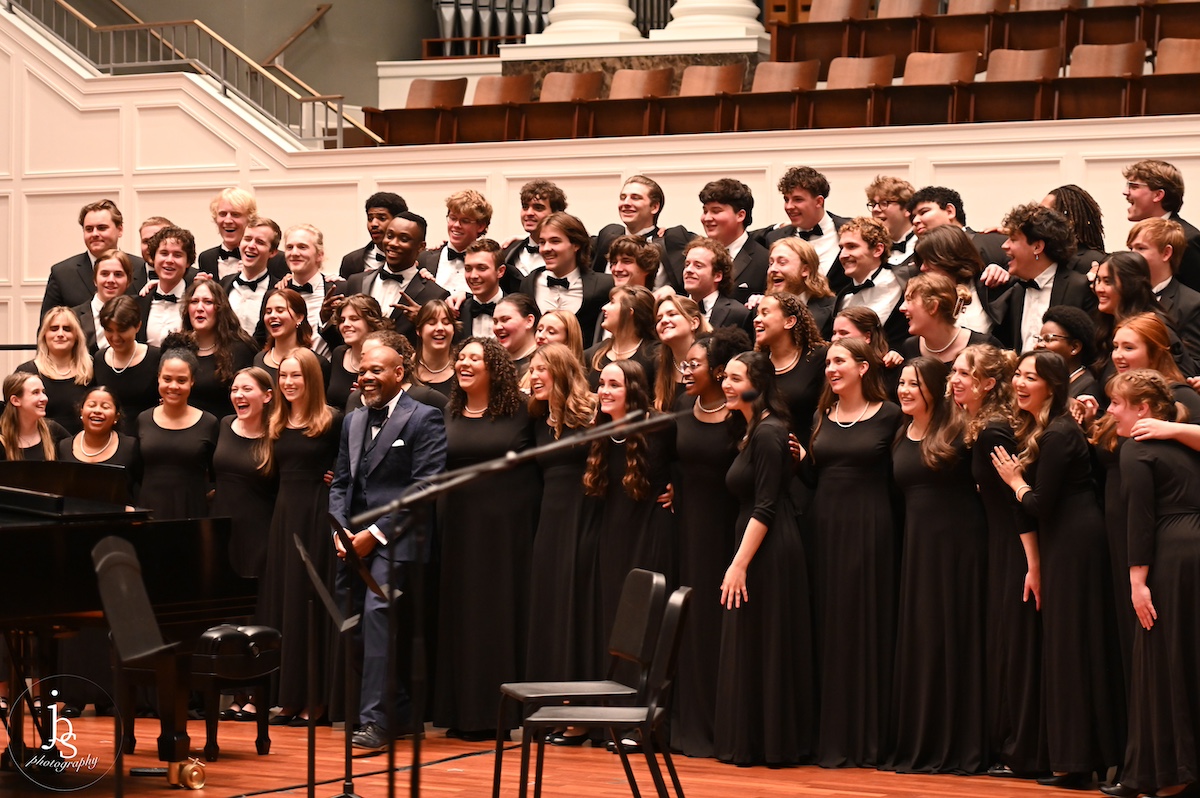 Chorale ensemble bowing on stage with director Dr. Jeffrey Ames