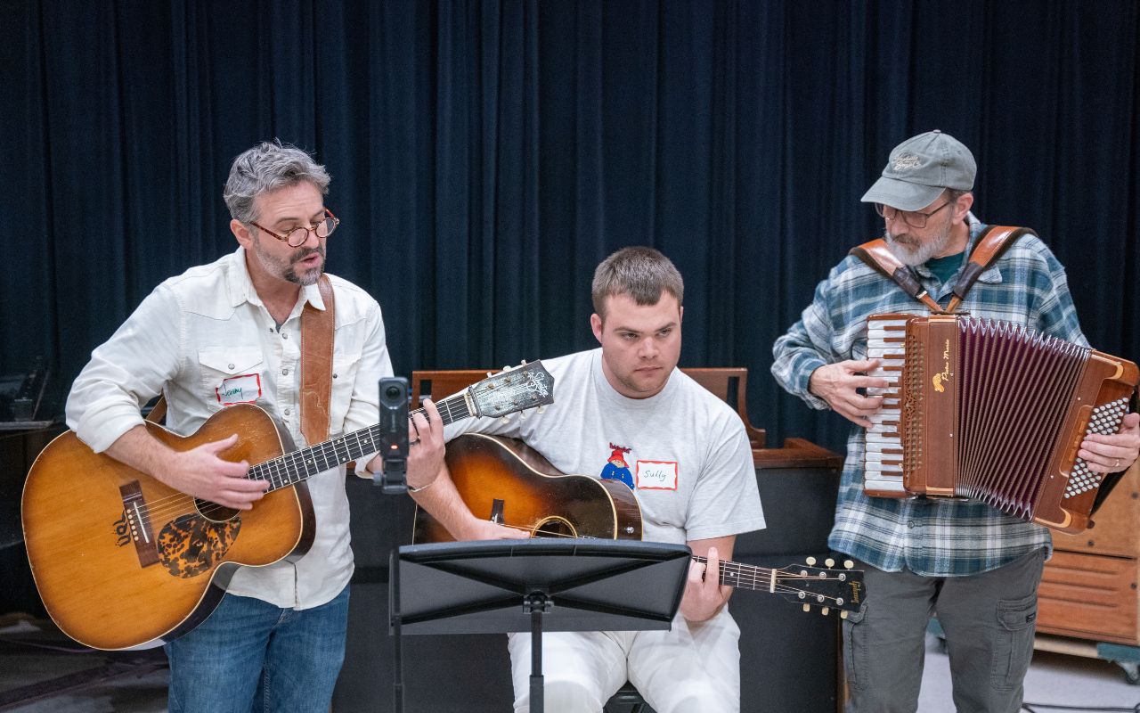 Group performs a song with two guitars and an accordion