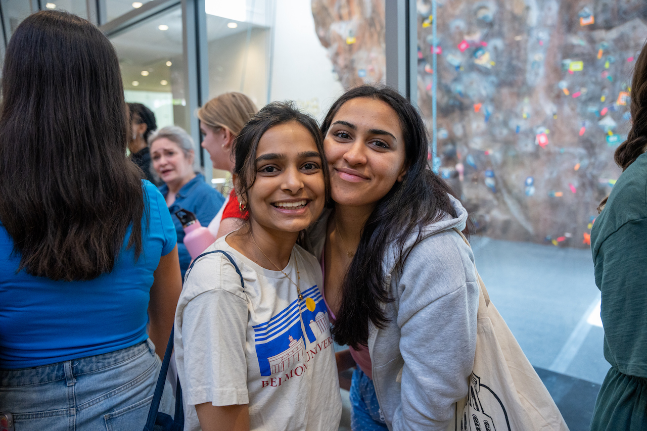 Two female students pose and smile