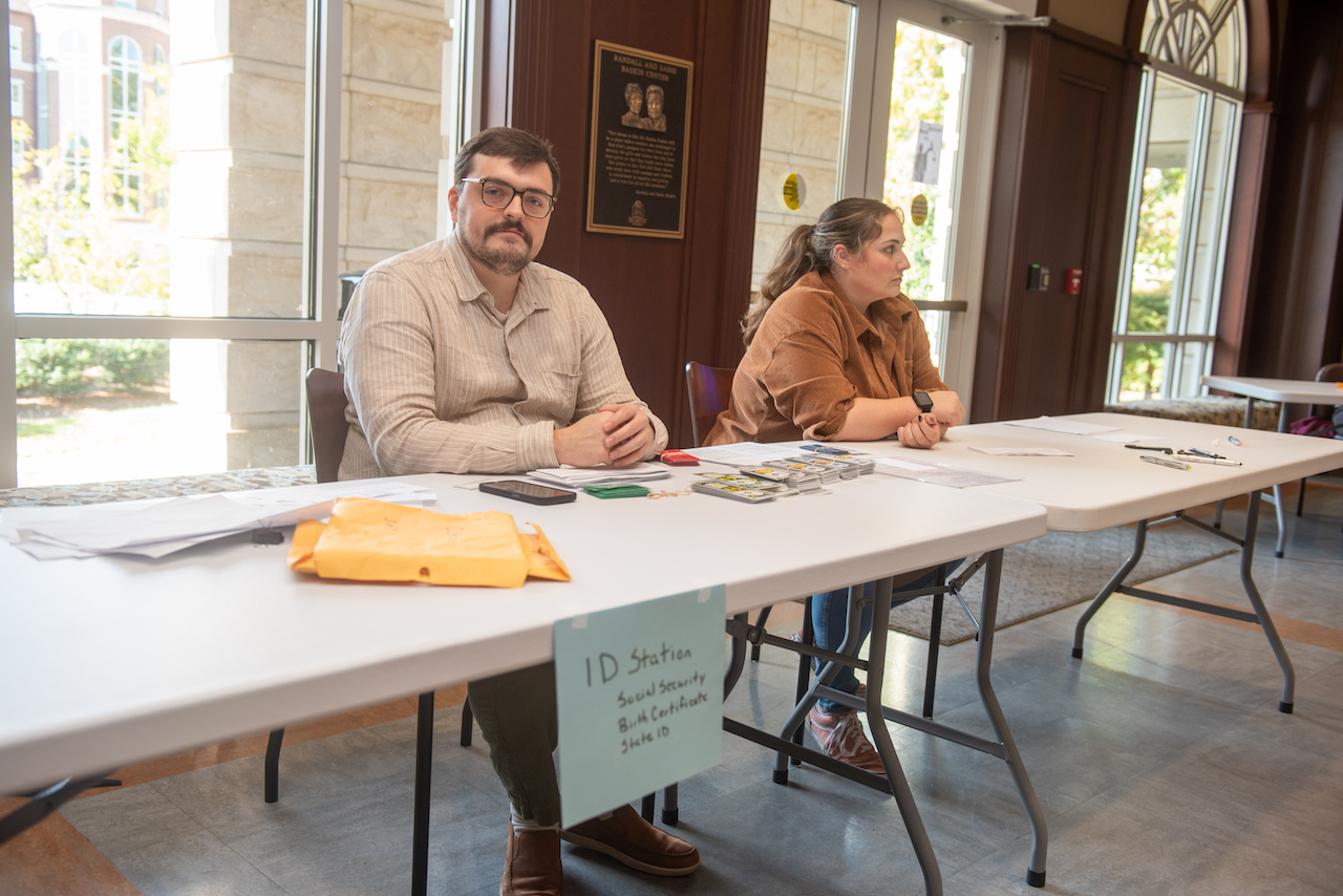 Two people sitting at ID tables