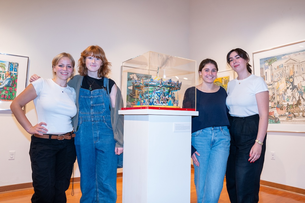 students involved pose with a central piece of the gallery