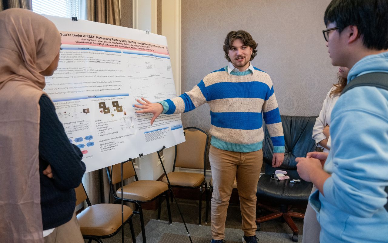 Two students present their poster to more students